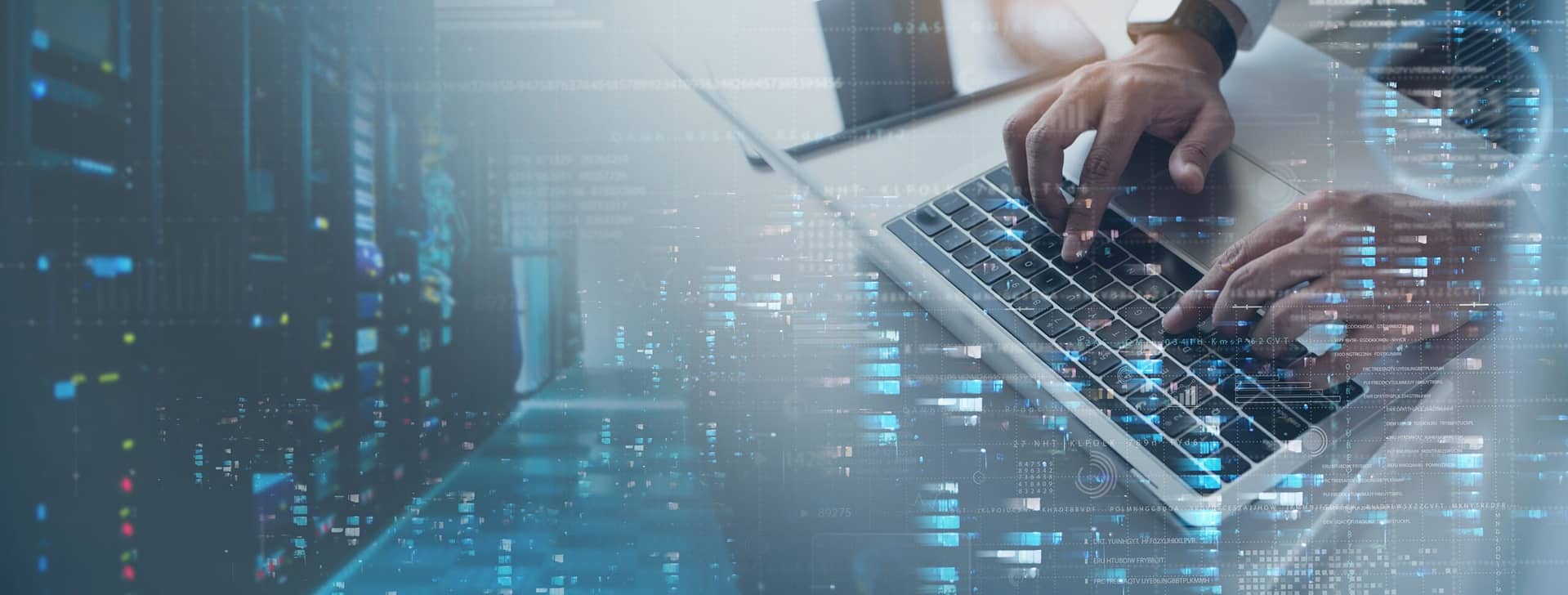 Hands typing on a laptop with a digital data overlay representing a high-tech environment.